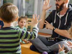 孩子们在鼓励孩子们的志愿者和老师玩耍