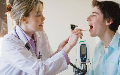 女医生检查青少年病人的喉咙