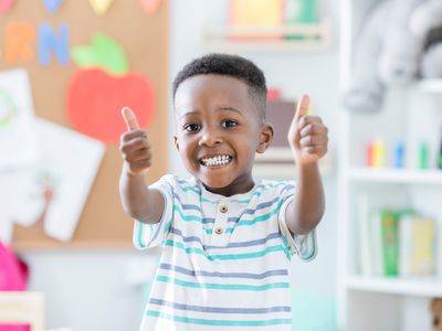 young boy giving two thumbs ups