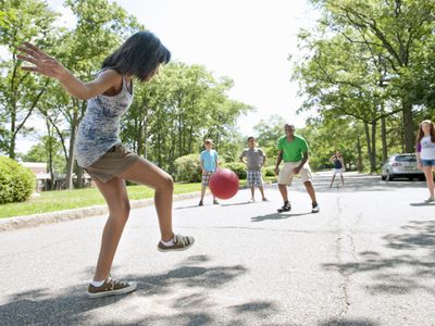 Girl kicking kickball in game
