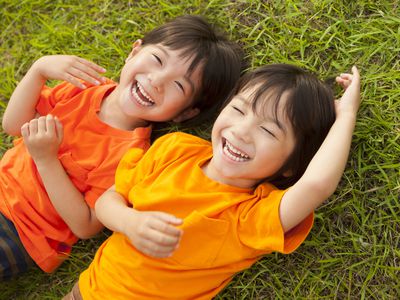 双胞胎男孩躺在草地上