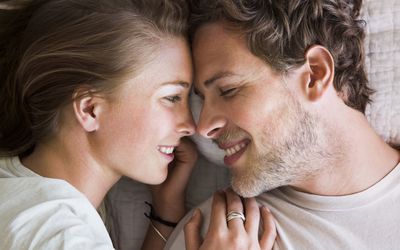 夫妇in bed close up, smiling at each other