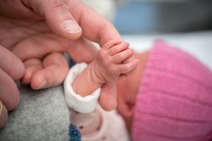 成人握着新生婴儿的手