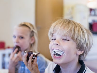 Laughing boy eating cupcake