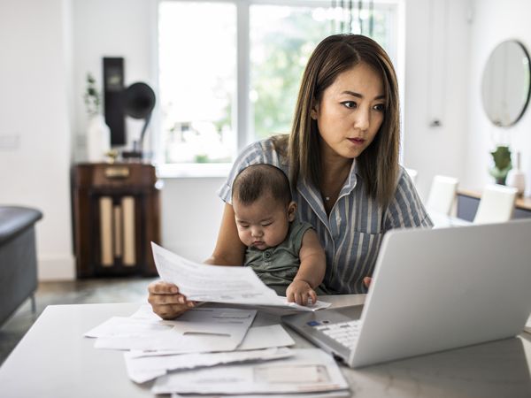 Woman works with infant baby in her lap