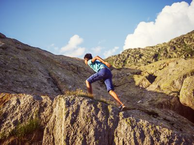 Boy climbing up rocks