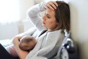 疲惫的母亲正在给新生儿喂奶。
