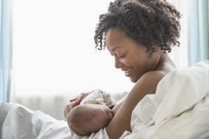 Mixed race mother nursing newborn baby
