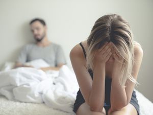 沮丧的女人坐在床上