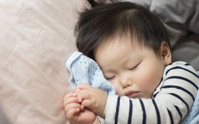 婴儿睡在毯子上
