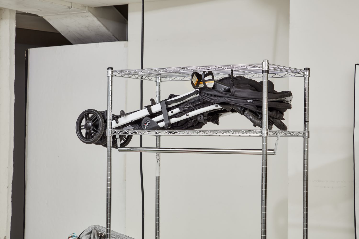 Folded Chicco Bravo Trio Travel System stored in a rack