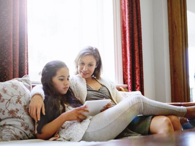 Mother with her tween daughter sitting on a couch