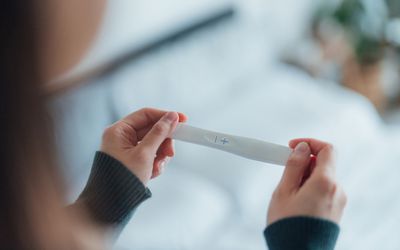 Person holding positive pregnancy test