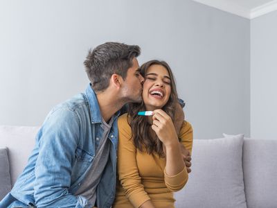 Happy couple looking at pregnancy test.
