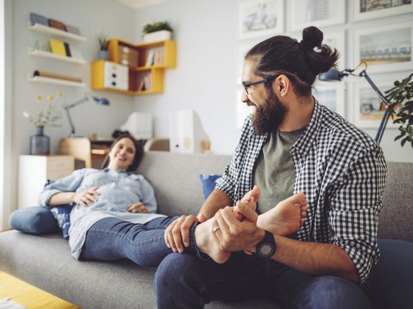 Man rubbing pregnant woman's feet