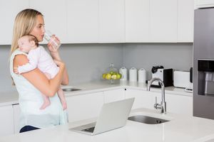一个抱着婴儿的女人喝水的画面。