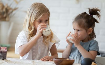 孩子们在厨房的桌子上喝牛奶