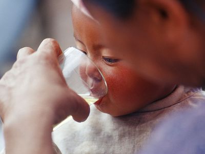 Baby drinking water from a glass