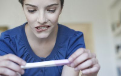 妇女拿着家里的验孕棒，看起来很担心华体会体育官方人口