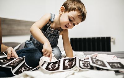 小男孩正在看他怀孕母亲的超声波扫描