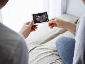 母亲和父亲拿着婴儿的超声波图