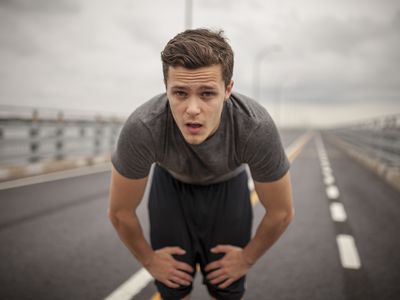 Man on long highway leaning over from fatigue, a possible symptoms of low testosterone levels