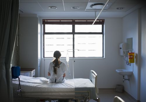 一个女人坐在病床上等待