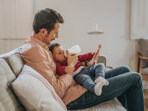 父亲用奶瓶喂婴儿无乳糖配方奶粉
