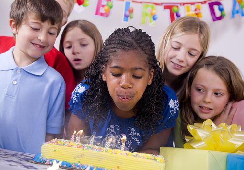 孩子们吹灭生日蛋糕上的蜡烛