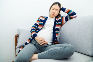 一个闭着眼睛坐在沙发上的孕妇