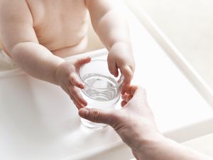 母亲递给婴儿一杯水