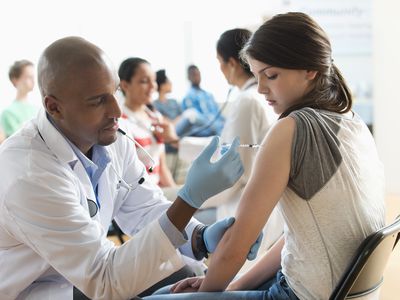 Doctor giving patient injection in volunteer clinic