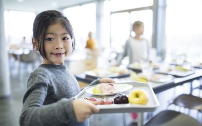 女孩端着学校的午餐托盘