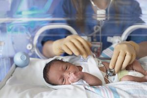 女医生在保温箱里检查新生儿
