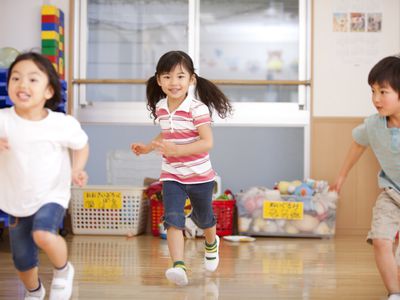 three little children running in play room