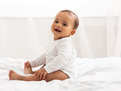 Baby sitting on bed