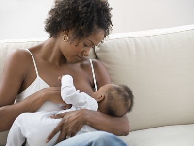 妇女母乳喂养ing her young infant
