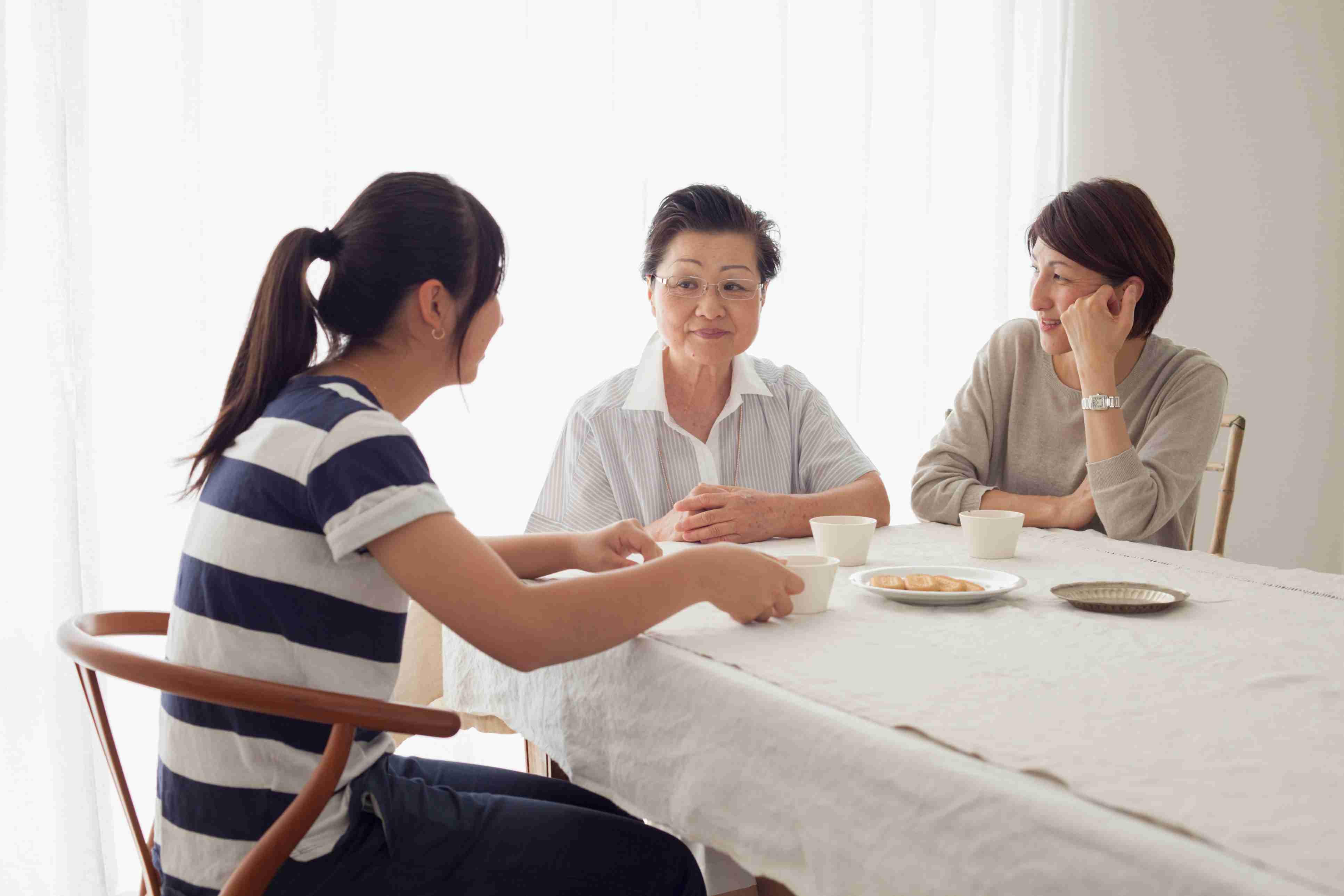 祖母、母亲和女儿坐在桌旁