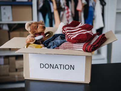 Box labeled donation full of kids clothes and toys