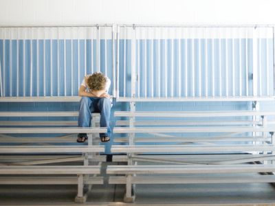Boy upset in bleachers at school