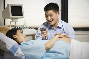 “男人和孕妇坐在一起，手里拿着秒表，微笑着”