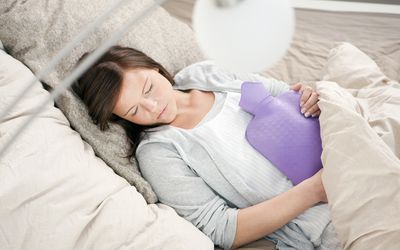 女人抱着热水瓶睡觉