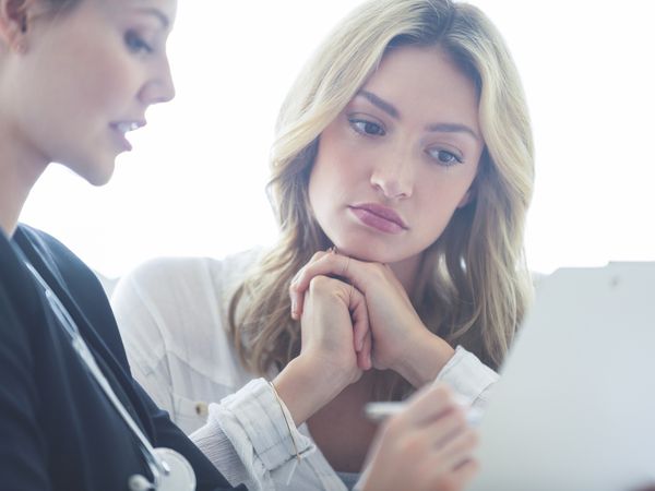 upset woman talking with healthcare provider about a miscarriage