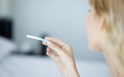 Woman looking at an ovulation test strip