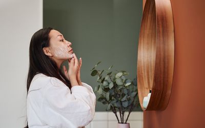 年轻女子在脸上涂抹保湿霜