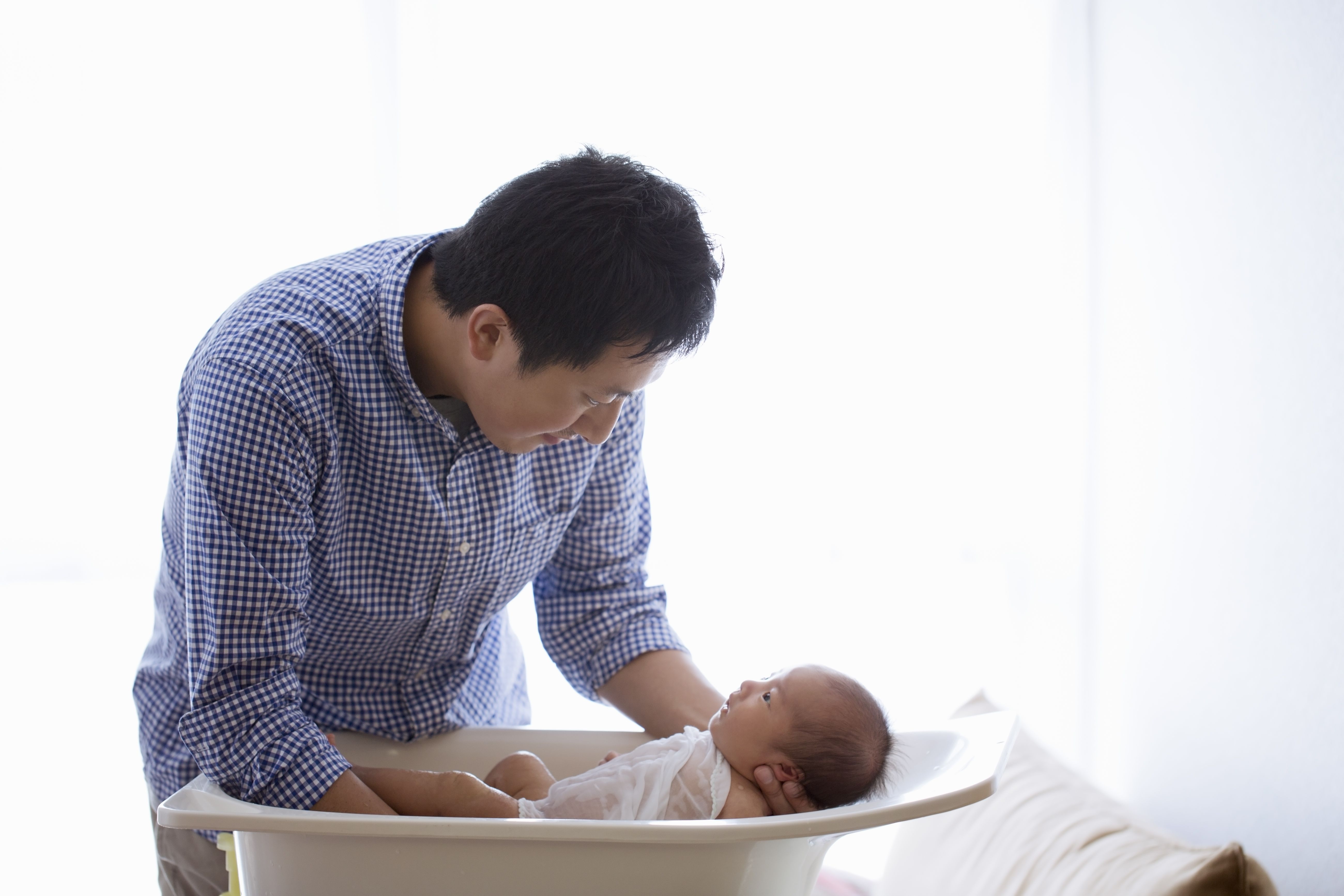 父亲用婴儿浴给他的婴儿洗澡。