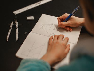 teen doing math problems in a notebook