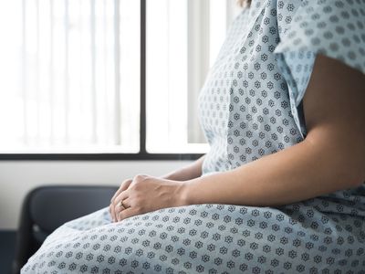 Midsection of female patient waiting in hospital exam room
