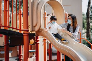 妈妈和女儿穿着面具在公园里