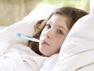 Girl in bed with thermometer in mouth